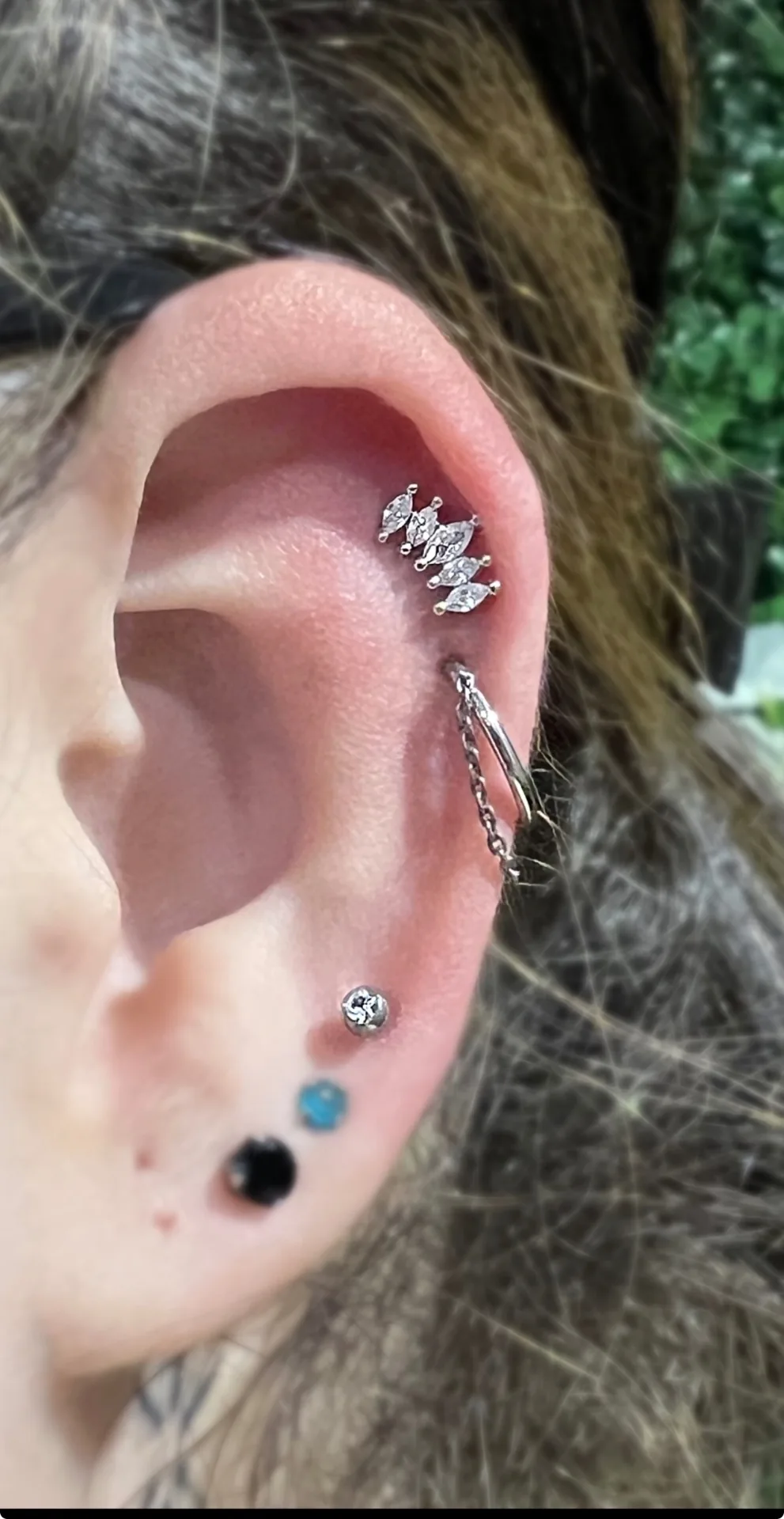 Piercing helix chaîne Paris Piercing helix avec chaîne titane réalisé au studio Showtime Tattoo Paris