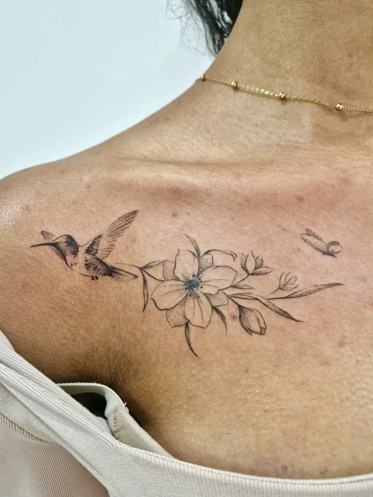 Tatouage colibri fineline Paris Tatouage colibri fleur fineline sur clavicule réalisé au studio Showtime Tattoo Paris Châtelet